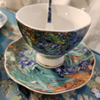 artfully designed tea cup. saucer, and spoon with purple iris print