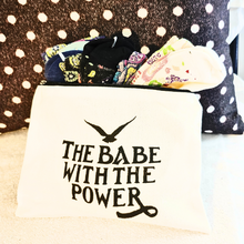  gift set includes a pair of ladies socks and a make up bag with a zipper.  the bag says 'the babe with the power' and is printed front and back.  the socks are beautiful paisley floral, colors vary.  